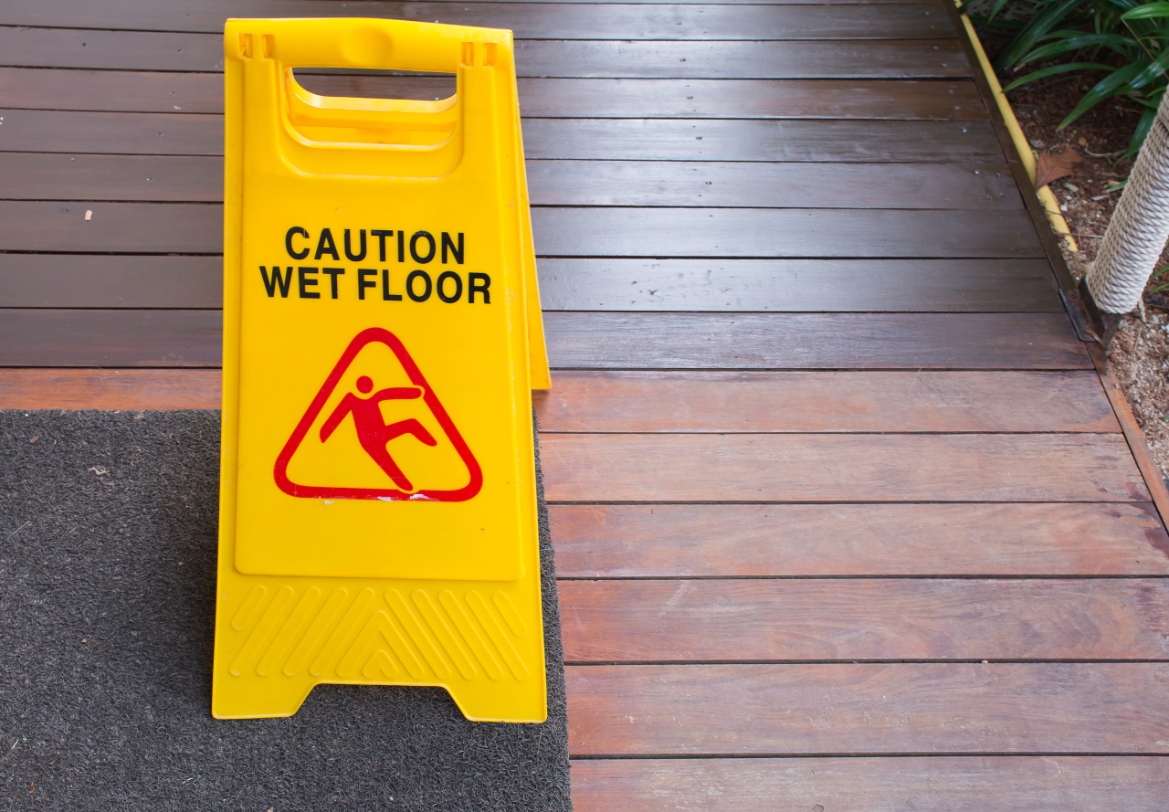 Yellow Sign warning  with "caution wet floor" text on a wooden floor